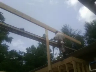 Carpenter setting a ridge beam over a new addition frame — Ice Dam Removal by Roofing Brothers in Menahga