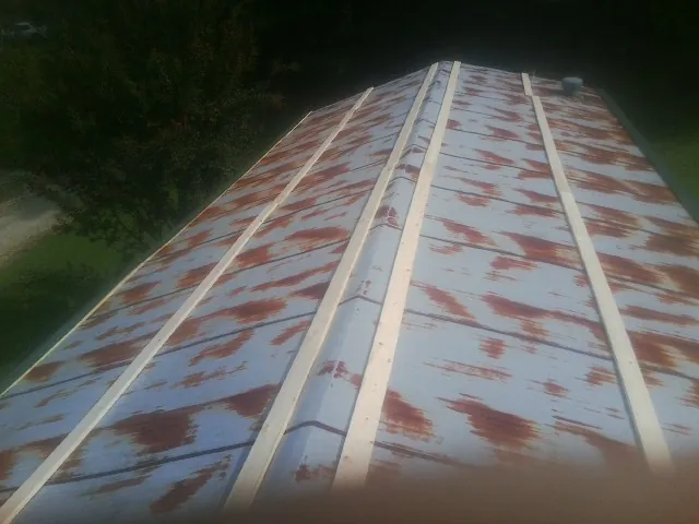 Rusted metal roof panels with new wood purlins before replacement — Storm Damage Roof Repair in Menahga by Roofing Brothers
