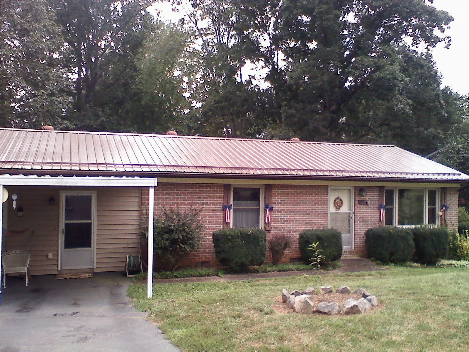 Bronze metal roof and carport on a brick ranch home — Roof Repair work by our crew in Menahga